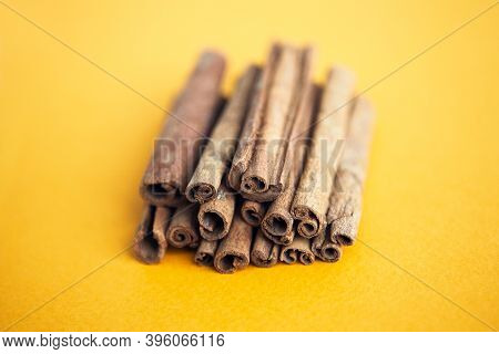 Cinnamon Sticks On The Yellow Background  With Copy Space For Your Text