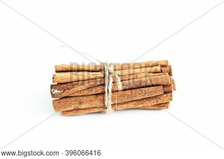 Cinnamon Sticks Held Together With Rope On The White Background