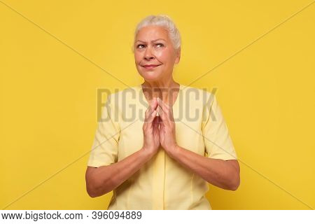 Senior Confident And Tricky Woman Holding Fingers Together And Smirking Aside, Having Some Tricky Id