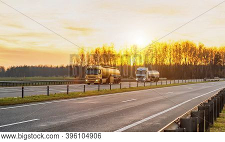 Trucks With Semi-trailers In Tanks Transport Fuel, Lubricants, Gasoline And Diesel Fuel On The Highw