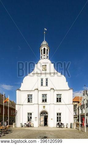 Wolgast, Germany - April 15, 2014: People Enjoy Sitting In Fron Of Famous Historic Town Hall Facade 