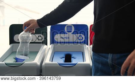Close-up Of Man Throwing Garbage Into Sorting Bins. Media. Man Throws Garbage Into Colored Bins For 
