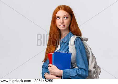 Creative And Thoughtful Cute Daring Foxy Girl With Red Hair, Hold Backpack And Notebooks, Biting Lip