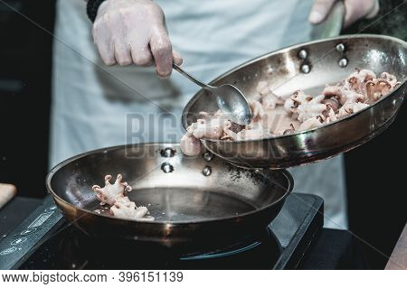 The Chef Cooks The Small Octopus On A Metal Frying Pan