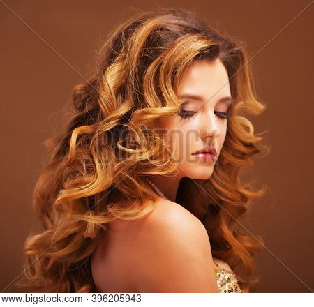 Beaity and fashion concept: Blond woman with long, healthy and shiny curly hair . Beautiful model woman with wavy hairstyle .Care and beauty.