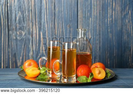 Delicious Plum Liquor, Mint And Ripe Fruits On Blue Wooden Table. Homemade Strong Alcoholic Beverage