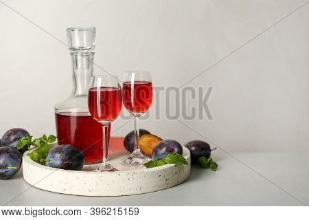Delicious Plum Liquor, Mint And Ripe Fruits On Light Table. Homemade Strong Alcoholic Beverage