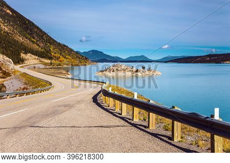 Asphalt highway leads to Abraham Lake. Magnificent Indian summer in the Canadian Rockies. The  Rocky Mountains, Canada