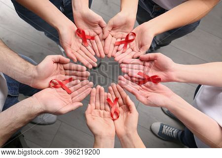 Group Of People Holding Red Awareness Ribbons Indoors, Above View. World Aids Disease Day