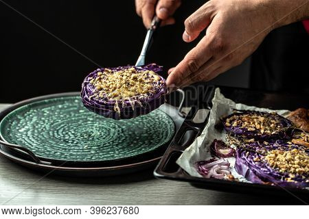 Chef Finishing Her Plate. Only Hands. Finally Dish Dressing Red Cabbage Baked With Nuts, Quince And 
