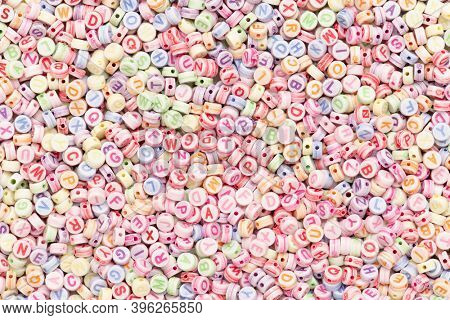 Pastel English letter alphabet beads background