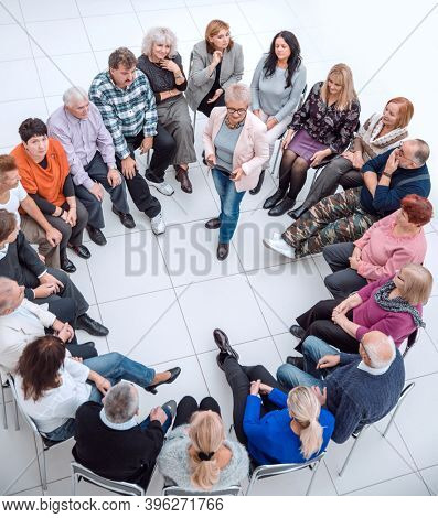 confident older woman standing in a circle of like-minded people