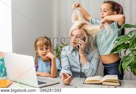 Home Office. Working From Home Vs. Mom With Two Kids Work On The Internet On A Laptop At Home. Quara
