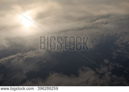 Looking Down Into Calm Reservoir Water Reveals The Reflected Warm Golden Evening Sky, Which Contains