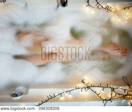 Women's Legs In The Bathtub, Bathing With Bubble Bath Foam Top View, Relaxtion Beauty Spa Concept Cl