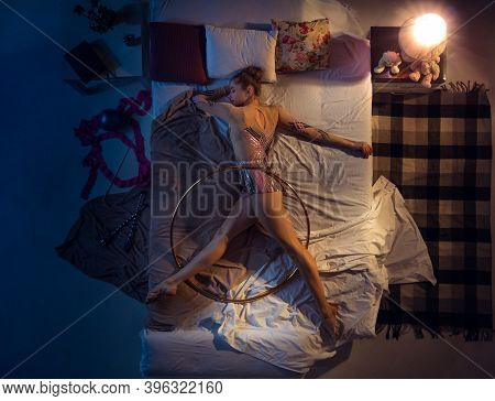 Action In A Dream . Top View Of Young Professional Rhythmic Gymnast Sleeping At Bed In Sportwear Wit