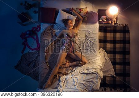 Relaxation . Top View Of Young Professional Rhythmic Gymnast Sleeping At Bed In Sportwear With Hoola