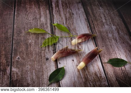 Mioga With Leaves On A Wood Background