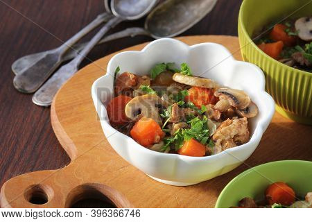 Meat Stew With Vegetable And Mushrooms In Bowl On Rustic Wooden Background