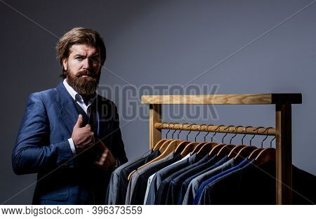 Male Suits Hanging In A Row. Men Clothing, Boutiques. Tailor, Tailoring. Stylish Mens Suit. Man Suit