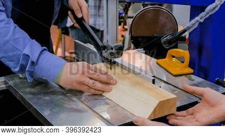 Professional Man Carpenter Hands Using Electric Bandsaw Tool, Cutting Piece Of Wood At Workshop - Cl