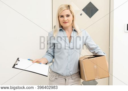 Transportation, Post And People Concept - Smiling Young Woman Opening Cardboard Box At Home