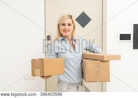 Transportation, Post And People Concept - Smiling Young Woman Opening Cardboard Box At Home