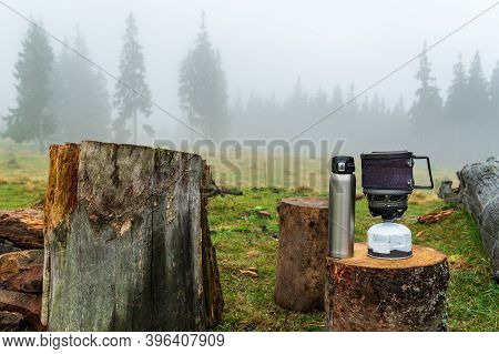 Preparing A Hot Drink For A Hike. Hot Coffee In A Thermos. Gas Stove And Thermos.