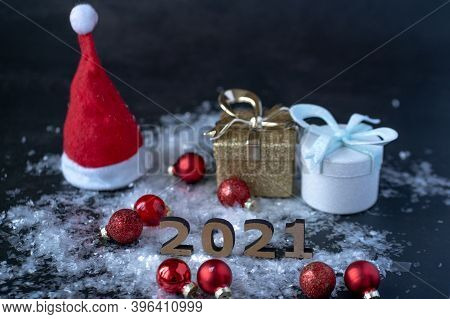 The Numbers Of The New Year 2021 Stand On White Snow Next To Scattered Red Balls Of Christmas Tree D