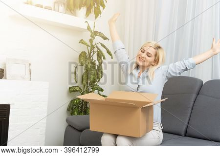 Transportation, Post And People Concept - Smiling Young Woman Opening Cardboard Box At Home