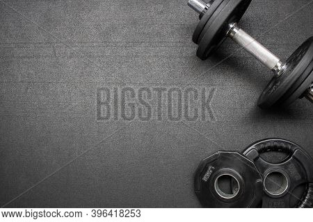 Barbell And Dumbbells On The Floor At The Gym. Top Down View Flat Lay With Bodybuilding Equipment On