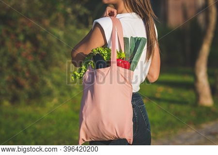Young Woman Holding Pink Reusable Textile Grocery Bag With Fresh Bio Vegetables. Plant Based Vegan D