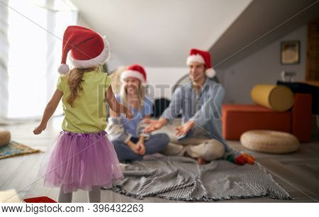 Merry parents spening Christmas time together with their kid at home