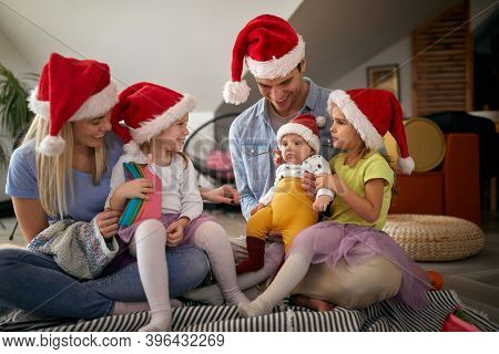 Cheerful parents spening Christmas time together with their kids; Family holiday concept