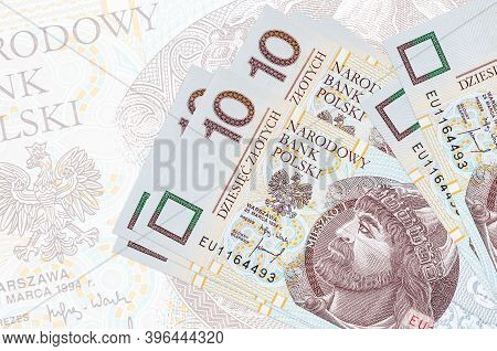 10 Polish Zloty Bills Lies In Stack On Background Of Big Semi-transparent Banknote. Abstract Present