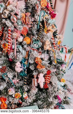 Christmas Gifts For Kids Under The Tree. Christmas Tree Decorated With Toys And Colorful Candy Canes