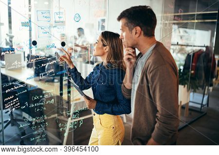 Business Solutions, Technology And Strategy Concept. Colleagues Working And Brainstorming In Office