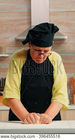Grandmother Preparing Wheat Homemade Bread Wearing Chef Bonete. Retired Elderly Baker With Bonete Mi