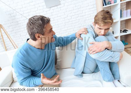 Father Sitting Near On Couch, Tries To Talk To His Son, But Problem Teenager Doesn't Want To Listen.
