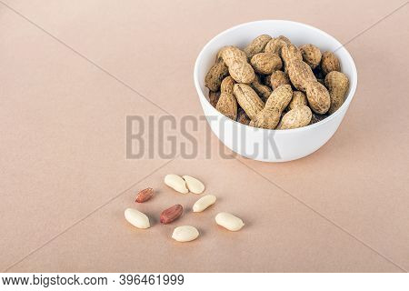 Unpeeled Peanuts In White Bowl On Sacking. Treats For Indian Canadian Punjabi Holiday Festival Of Lo