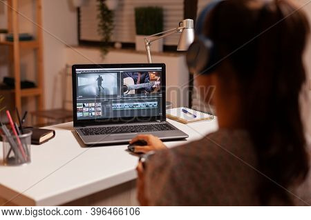 Filmmaker Editing Video Footage During Night Time In Home Kitchen. Content Creator In Home Working O