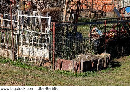 Cluttered Old Family House Backyard Filled With Construction Material Mixed With Tree Branches And O