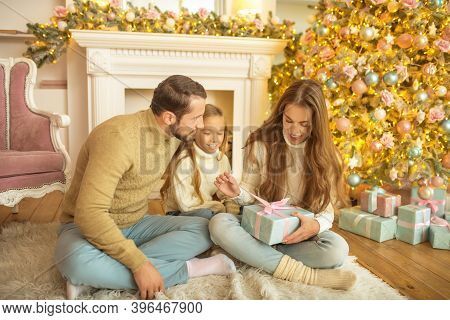 Young Family Feeeling Happy Opening Christmas Gifts