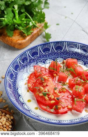 Stracciatella Salad With Tomatoes And Watermalone And Ingredients On Light Concrete Table
