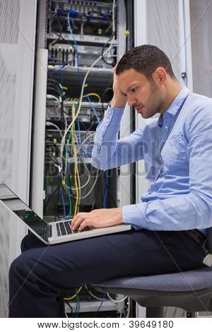Data tekniker får understreget over servere med laptop