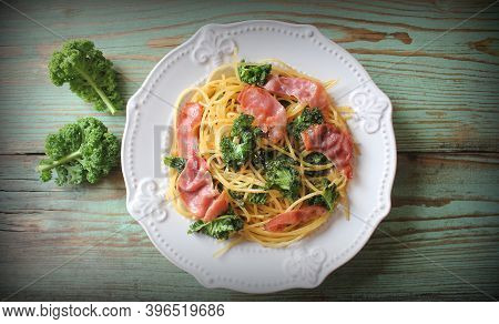 Delicious Linguine Pasta With Fried Cabbage Kale, Bacon, Garlic And Parmesan On A White Plate .