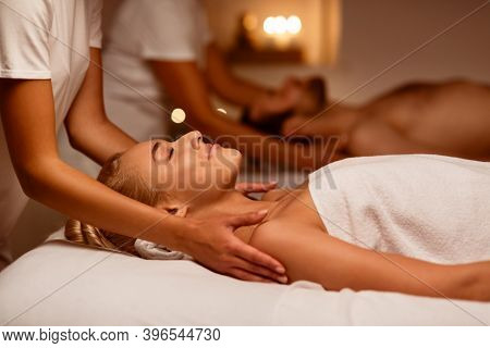 Couples Massage. Girlfriend And Boyfriend Enjoying Relaxing Beauty Treatment Lying In Masseurs Bed A