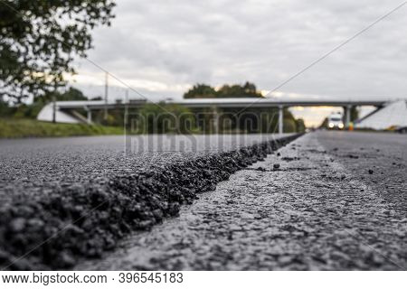 A Large Layer Of Fresh Hot Asphalt. Layer Of Asphalt Raw Material In A Shallow Depth Of Field. Rolle