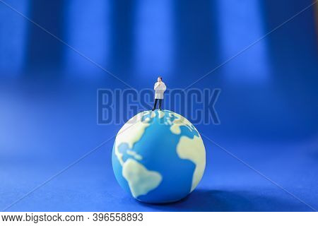 Global Healthcare Concept. Docter And Nurse Miniature Figure People With Facemask Standing On Mini W