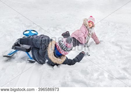 A Happy Boy And Girl Having A Fun Together, Lying In The Snow.